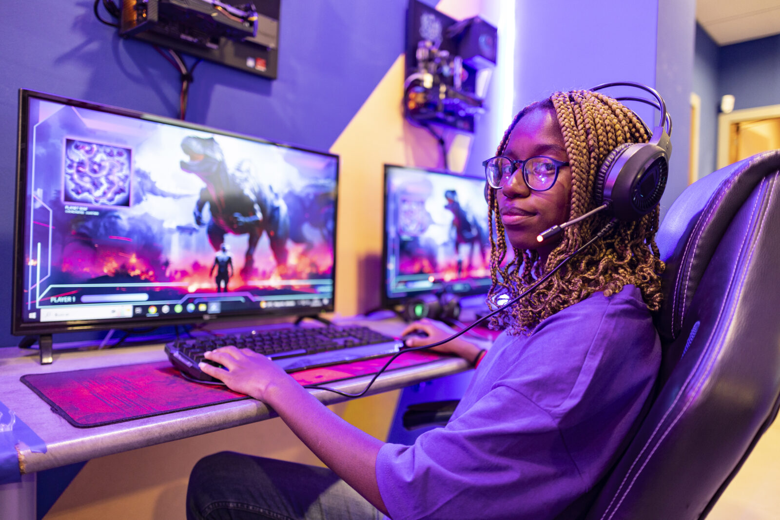 Gamer girl playing online video game using computer and headset