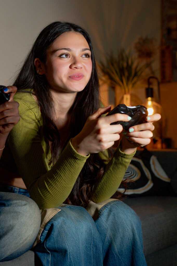 Lesbian couple playing videogames on sofa at home